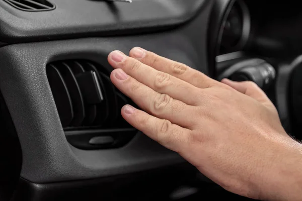 Mann hält Hand in Nähe von Lüftungsgitter im Auto, Nahaufnahme — Stockfoto