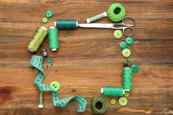 Colorful threads and sewing accessories on wooden background — Stock Photo, Image