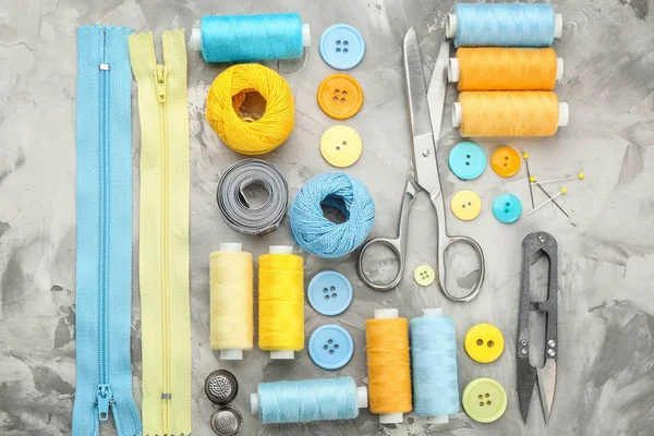 Kleurrijke draden en naai accessoires op grijze achtergrond — Stockfoto