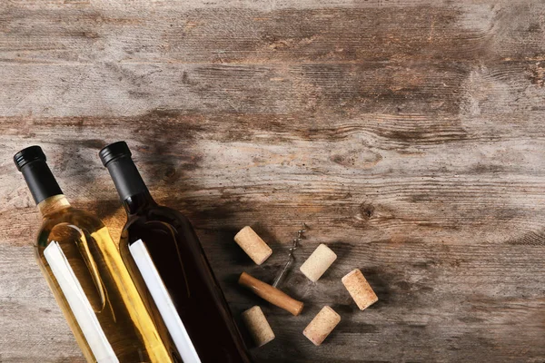 Zwei Flaschen Rot- und Weißwein auf Holzgrund — Stockfoto