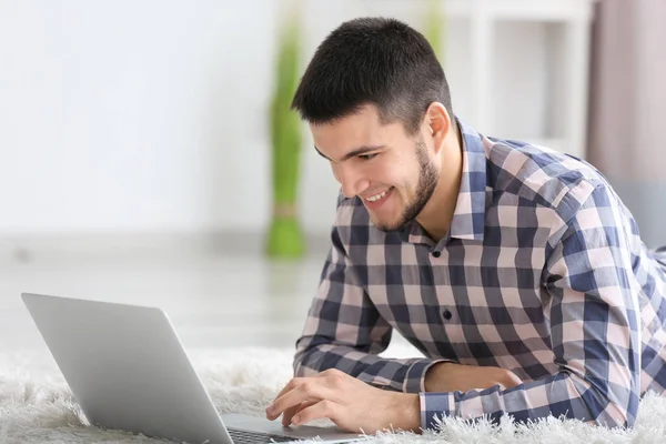 Hombre joven usando el ordenador portátil moderno en casa —  Fotos de Stock