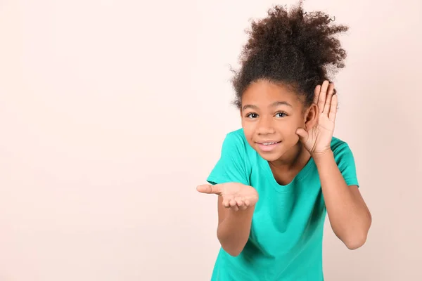 Piccola ragazza afro-americana con problemi di udito su sfondo chiaro — Foto Stock