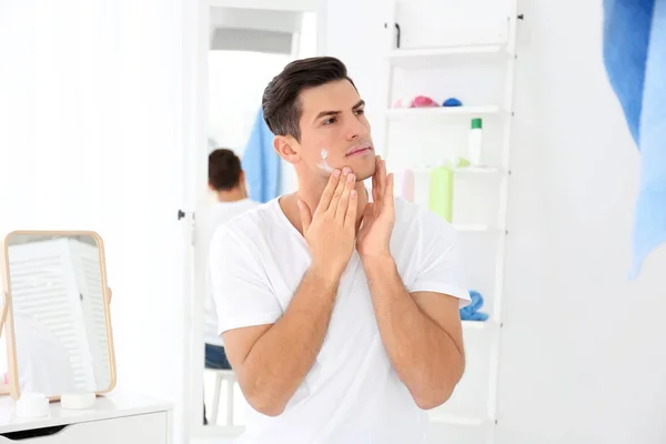 Bonito homem aplicando creme — Fotografia de Stock