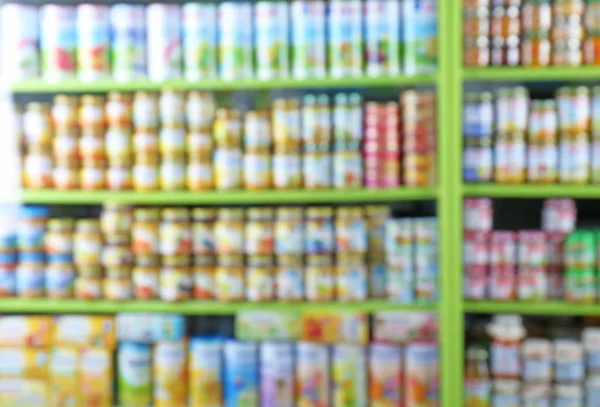 Vista borrosa de los estantes con comida para bebés en la tienda —  Fotos de Stock