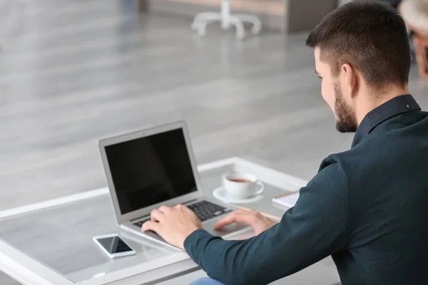 Hombre joven usando un ordenador portátil moderno, en el interior —  Fotos de Stock