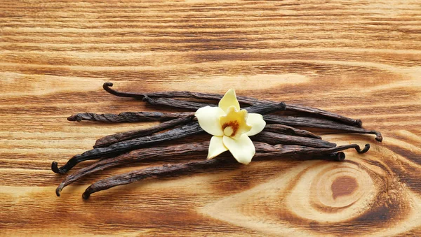 バニラ棒や木製の背景の花 — ストック写真