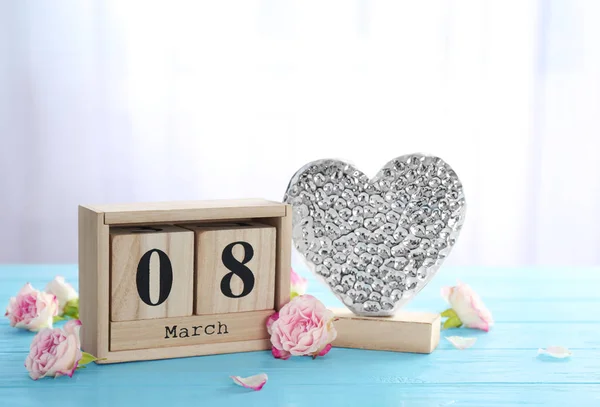 Деревянный календарь и декоративное сердце на столе. Композиция к Международному женскому дню — стоковое фото