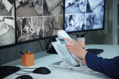 Kadın güvenlik görevlisi gözetim odasında telefon kullanma