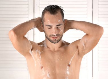 Genç yakışıklı adam alarak duş banyoda