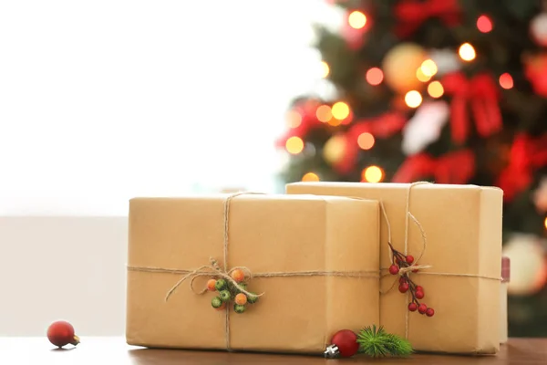 Wrapped gifts on table against blurred Christmas tree. Boxing day — Stock Photo, Image