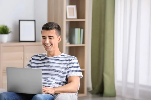 Jovem usando laptop moderno em casa — Fotografia de Stock