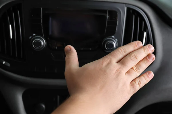 Man holding hand near air ventilation grille in car, closeup — Stock Photo, Image