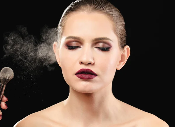 Vrouw toepassing van make-up op zwarte achtergrond. Werk van de kunstenaar professionele visage — Stockfoto
