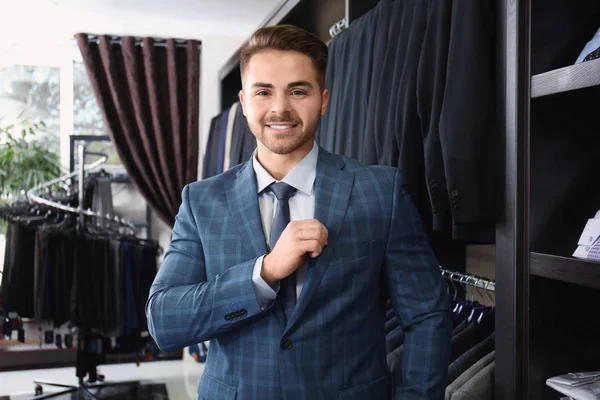 Handsome young man wearing suit in shop — Stock Photo, Image