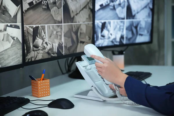 Kvinnliga säkerhetsvakt som använder telefon i övervakning rum — Stockfoto