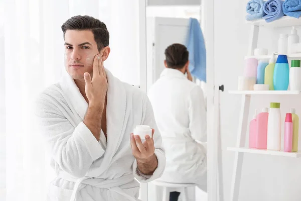 Hombre guapo aplicando crema —  Fotos de Stock