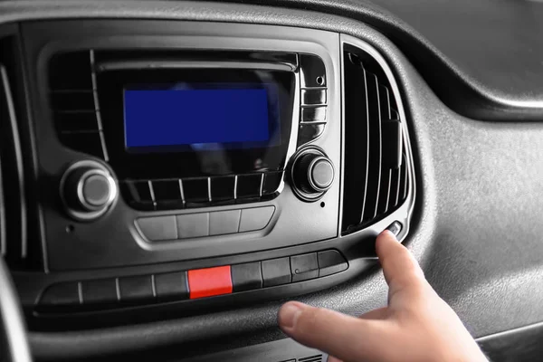 Man switching on air conditioner in car — Stock Photo, Image