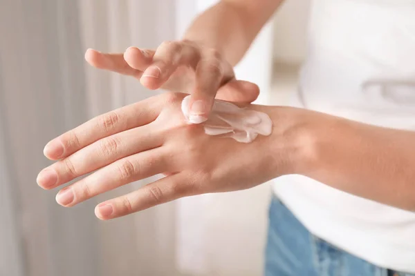 Giovane donna che applica la crema per le mani, primo piano — Foto Stock