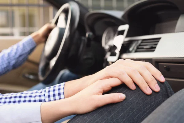 Hands of romantic young couple sitting in car — Stock Photo, Image