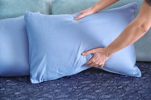 Mujer poniendo almohada suave en la cama cómoda, primer plano —  Fotos de Stock