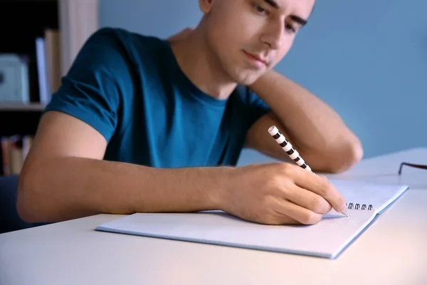 Studente di sesso maschile che si prepara per l'esame a tavola al chiuso — Foto Stock