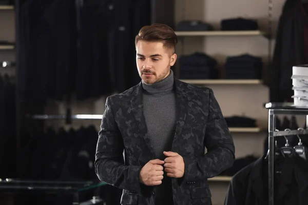 Hombre joven en ropa elegante en la tienda de ropa masculina — Foto de Stock