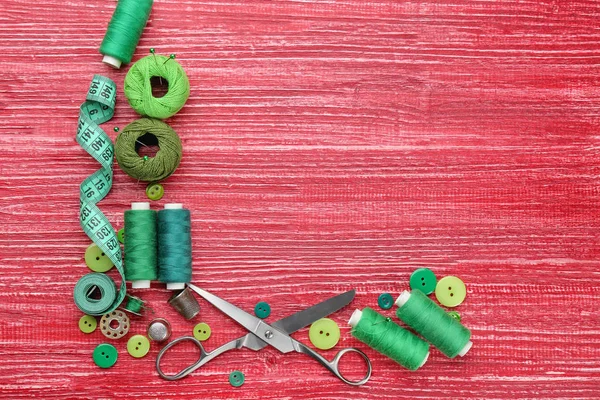 Hilos de colores y accesorios de costura sobre fondo de madera —  Fotos de Stock