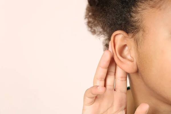 Menina afro-americana com problema de audição no fundo de luz — Fotografia de Stock