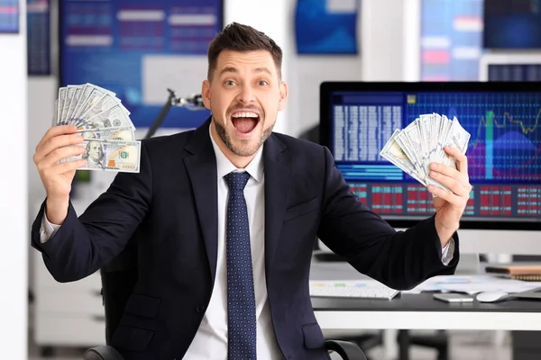 Comerciante de bolsa joven con dinero en el lugar de trabajo — Foto de Stock