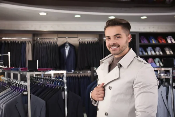 Giovane in elegante cappotto al negozio di abbigliamento maschile — Foto Stock