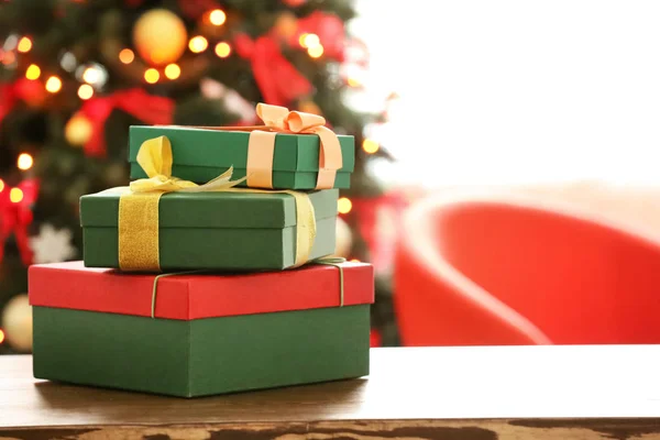 Regali avvolti sul tavolo contro l'albero di Natale sfocato. Giorno della boxe — Foto Stock