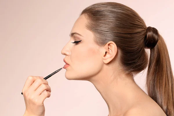 Profesionální vizáž umělce použití make-up na tvář na světlé pozadí — Stock fotografie