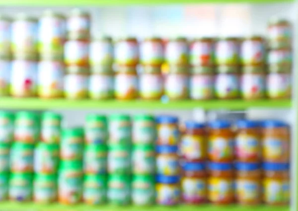 Blurred view of shelves with baby food in shop — Stock Photo, Image