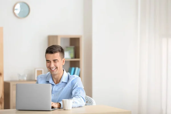 Hombre joven usando el ordenador portátil moderno en la mesa —  Fotos de Stock