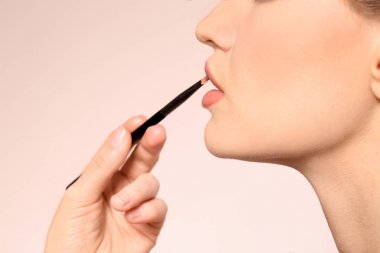 Açık renkli kadının yüzünde makyaj uygulayarak profesyonel visage sanatçı