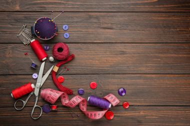 Renkli konu ve ahşap zemin üzerine dikiş aksesuarları