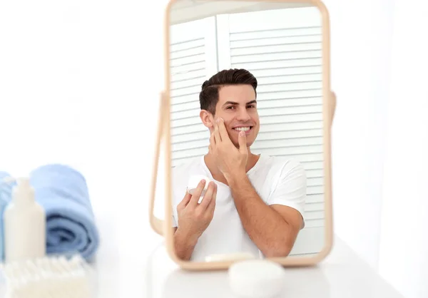 Hombre guapo aplicando crema —  Fotos de Stock