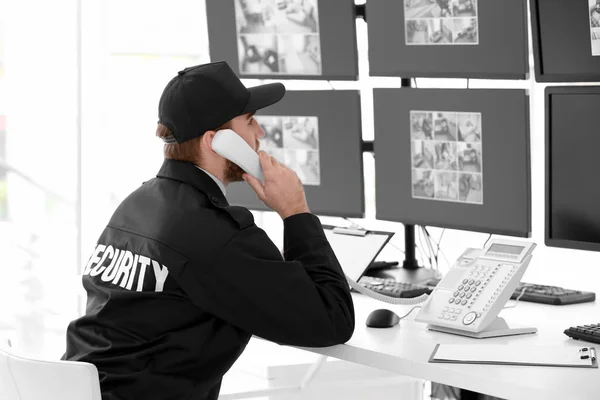 Mannelijke bewaker praten via de telefoon in de kamer van toezicht — Stockfoto