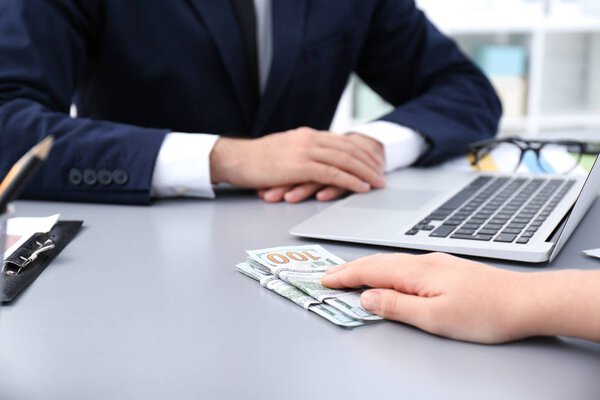 Женщина дает взятку бизнесмену в помещении, крупным планом
