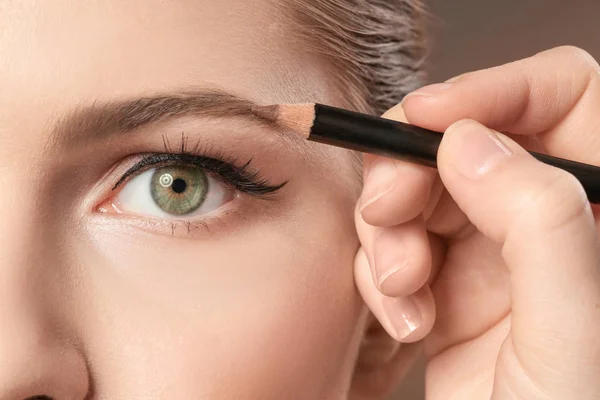 Professional visage artist applying makeup on woman's face, closeup — Stock Photo, Image