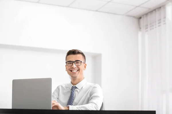 Jonge man in een overhemd met behulp van laptop op werkplek — Stockfoto