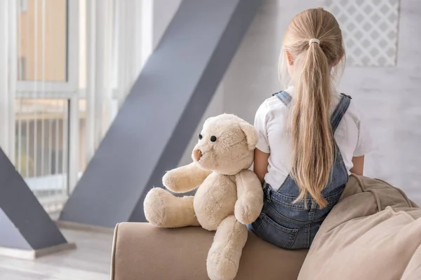 Самотня дівчинка з плюшевим ведмедем у кімнаті. Концепція аутизму — стокове фото