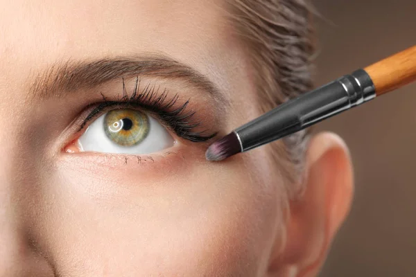Vrouw make-up toe te passen op de achtergrond in kleur. Werk van de kunstenaar professionele visage — Stockfoto