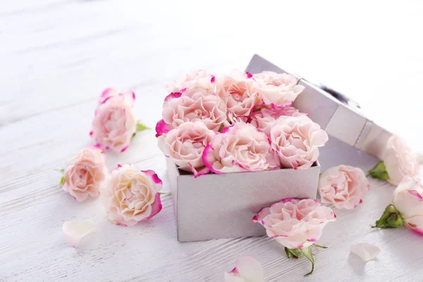 Dárková krabice s květinami na dřevěný stůl — Stock fotografie