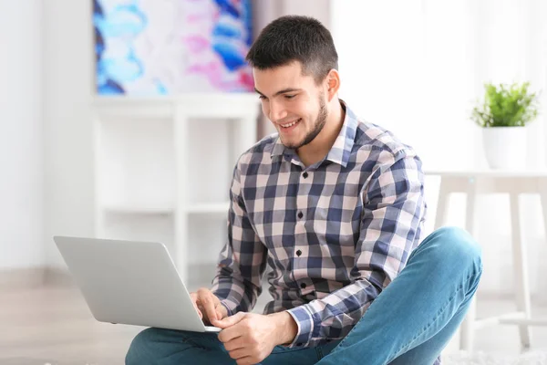 Giovane uomo che utilizza il computer portatile moderno a casa — Foto Stock