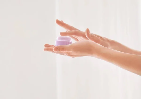 Jeune femme avec pot de crème pour les mains à la maison — Photo