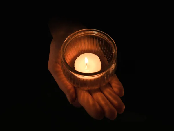 Young woman holding jar with burning candle in darkness — Stock Photo, Image