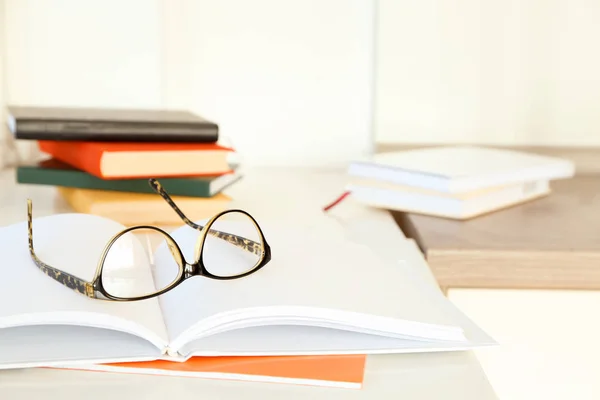 Glasses and notebook on table indoors. Preparation for exam — Stock Photo, Image
