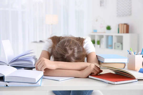 Estudiante cansada durmiendo en su escritorio. Preparación para el examen Imágenes de stock libres de derechos