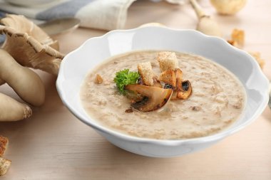 Ahşap masa üzerinde lezzetli mantar çorbası ile kase